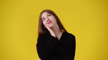 4k slow motion video of one girl looking side to side over yellow background. Concept of emotions.