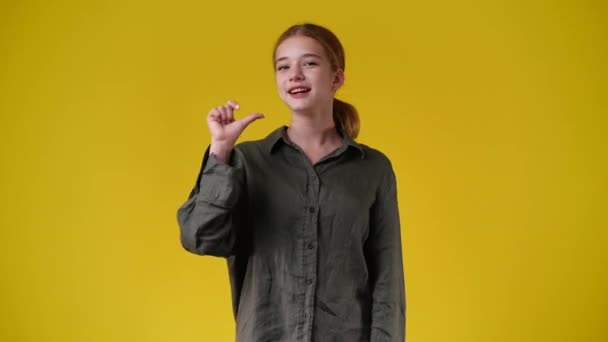 1人の女の子の4Kスローモーションビデオは黄色の背景にとても興奮しています 感情の概念 — ストック動画