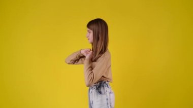 4k slow motion video of side view of one girl dancing over yellow background. Concept of emotions.