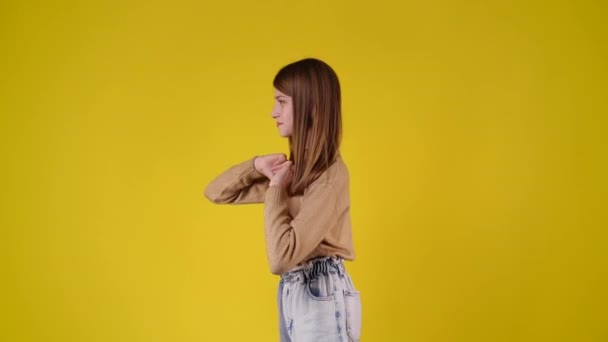 4K慢镜头 一个女孩在黄色背景上跳舞的侧影 情绪的概念 — 图库视频影像