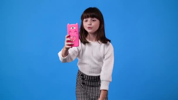 1人の女の子の4Kスローモーションビデオ青の背景にビデオコールを持っています 感情の概念 — ストック動画