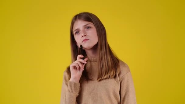 Zeitlupe Video Von Mädchen Mit Listigen Gesichtsausdruck Auf Gelbem Hintergrund — Stockvideo