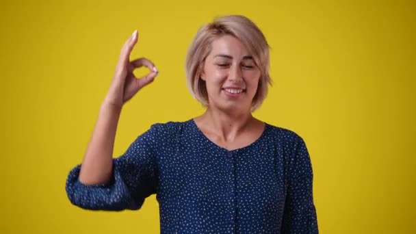 Slow Motion Video Cute Woman Showing Sign Yellow Background Concept — Vídeo de stock