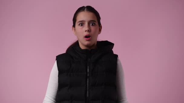 ピンクの背景にショックを受けた1人の少女の4K動画 感情の概念 — ストック動画