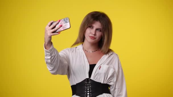 黄色い背景で自撮りしている美少女の4K動画 感情の概念 — ストック動画