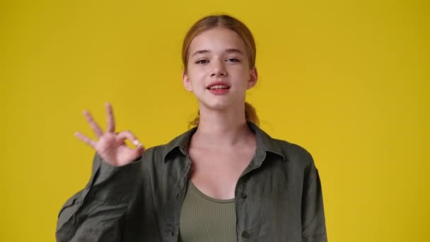 Zeitlupe Video Von Niedlichen Mädchen Zeigt Zeichen Auf Gelbem Hintergrund — Stockvideo