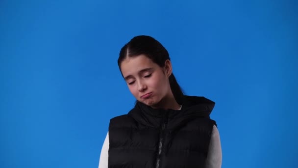 青い背景に何かを懇願する1人の少女の4Kスローモーションビデオ 感情の概念 — ストック動画
