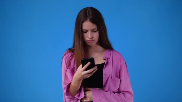 携帯電話を手にした女の子の表情の4Kスローモーションビデオ 感情の概念 — ストック動画