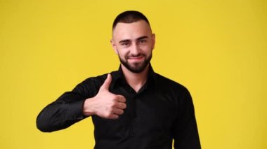 4k video of one man showing thumb up on yellow background. Concept of emotions.