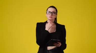 4k video of one girl taking notes over yellow background. Concept of emotions.