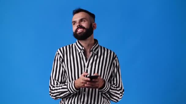 Видео Замедленной Съемки Одного Человека Использующего Телефон Над Синим Фоном — стоковое видео