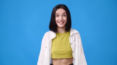 4k slow motion video of one girl feeling excited over blue background. Concept of emotions.