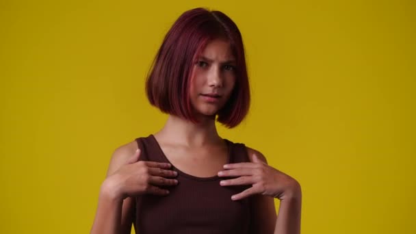 黄色の背景にないジェスチャー1人の女の子の4Kスローモーションビデオ 負の感情の概念 — ストック動画