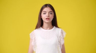 4k slow motion video of one girl feeling excited over yellow background. Concept of emotions.