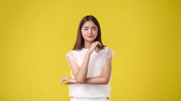 Slow Motion Video One Girl Uncertain Facial Expression Yellow Background — Vídeos de Stock