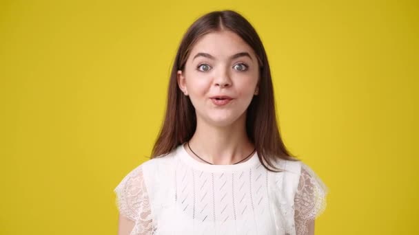 4K慢动作视频可爱的女孩在黄色背景上显示Ok标志 情绪的概念 — 图库视频影像