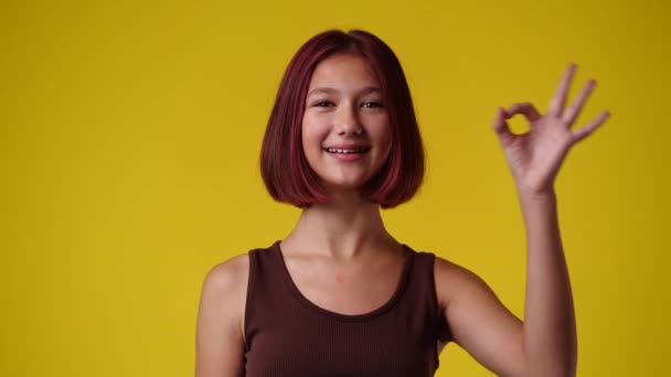 Αργή Κίνηση Βίντεο Από Χαριτωμένο Κορίτσι Δείχνει Σημάδι Στο Κίτρινο — Αρχείο Βίντεο