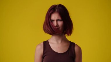 4k slow motion video of one girl gesturing no over yellow background. Concept of emotions.