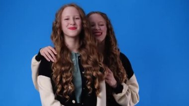 4k slow motion video of two twin girls smiling and looking at the camera. Concept of emotions.