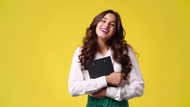 Slow Motion Video Smiling Girl Holding Note Book Yellow Background — Stockvideo