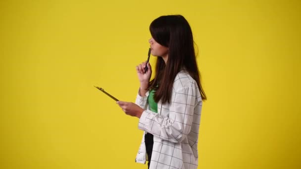 Slow Motion Video One Girl Taking Notes Yellow Background Concept — Stockvideo