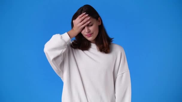 4K慢镜头 一个女孩在蓝色背景下头疼 情绪的概念 — 图库视频影像
