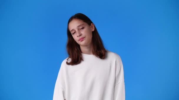 4K的慢动作视频一个女孩的负面面部表情在蓝色背景 情绪的概念 — 图库视频影像