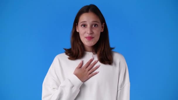青い背景の上にビデオをポーズしている1人の女の子の4Kスローモーションビデオ 感情の概念 — ストック動画