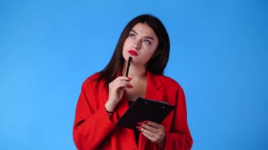 4k slow motion video of woman taking down some notes with a pen on blue background. Concept of emotions.