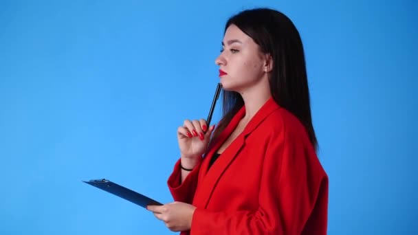 K青い背景にペンでいくつかのメモを取る女性のスローモーションビデオ 感情の概念 — ストック動画