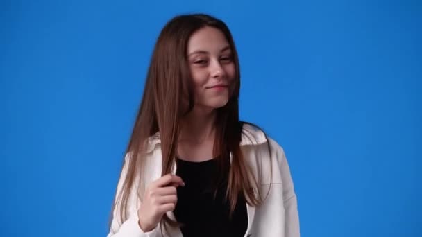 Lassított Felvétel Egy Lányról Aki Kék Háttérrel Pózol Egy Videóhoz — Stock videók