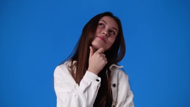 青い背景で何かを考えている1人の少女の4Kスローモーションビデオ 感情の概念 — ストック動画
