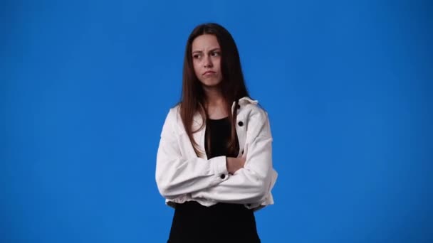 青を背景に否定的な表情をした1人の少女の4Kスローモーションビデオ 感情の概念 — ストック動画