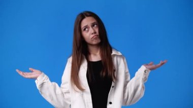 4k slow motion video of one girl gesturing no over blue background. Concept of emotions.