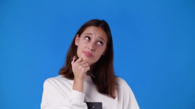 4k video of one girl thinking about something with a pen in hand. Concept of emotions.