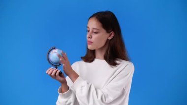 4k video of one girl looking at small globe. Concept of emotions.