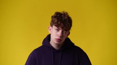 4k video of one man blinking an eye over yellow background. Concept of emotions.