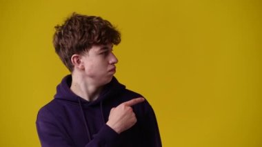 4k video of one man pointing at right and showing thumb up over yellow background. Concept of emotions.
