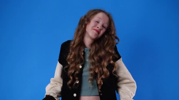 青を背景に否定的な表情をした1人の少女の4Kスローモーションビデオ 感情の概念 — ストック動画