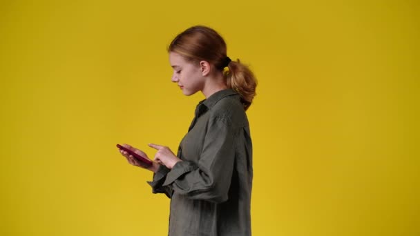 Βίντεο Γυναίκα Χρησιμοποιεί Τηλέφωνό Της Κίτρινο Φόντο Έννοια Του Συναισθήματος — Αρχείο Βίντεο