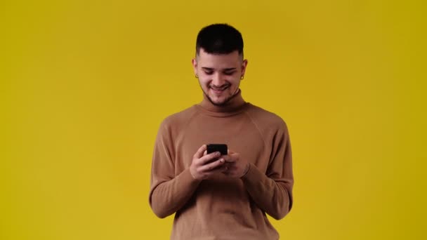 Video Hombre Usando Teléfono Sobre Fondo Amarillo Concepto Emoción — Vídeo de stock
