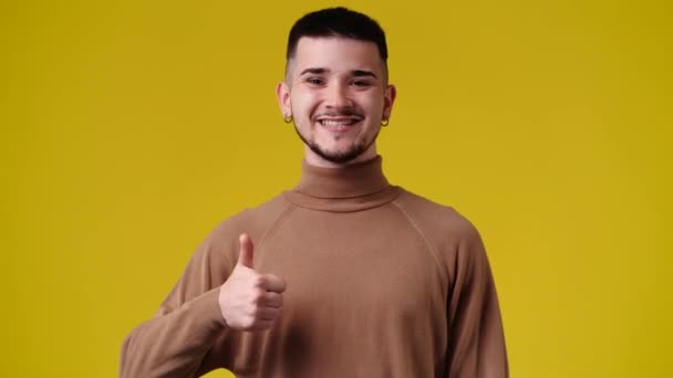 黄色の背景の上に親指を示す1人の男の4Kビデオ 感情の概念 — ストック動画