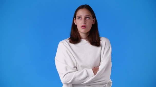 4K的慢动作视频一个女孩的负面面部表情在蓝色背景 情绪的概念 — 图库视频影像