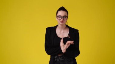 4k video of one upset girl thinking about something on yellow background. Concept of emotions.