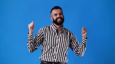 4k video of one man dancing and smiling over blue background. Concept of emotions.