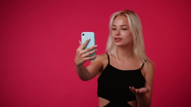 4K视频 一个女孩在电话里用粉色背景说话 情绪的概念 — 图库视频影像