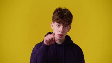 4k video of one man showing thumbs up and smiling over yellow background. Concept of emotions.