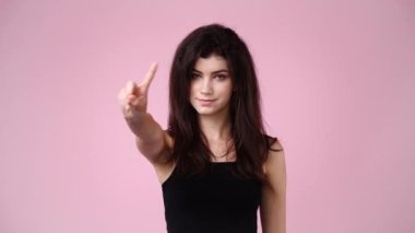 4k slow motion video of one girl who responds negatively to something over pink background. Concept of emotions.