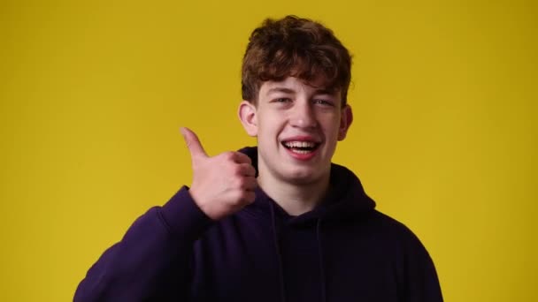 1人の男の4K動画が黄色の背景に親指を立てて微笑んだ 感情の概念 — ストック動画