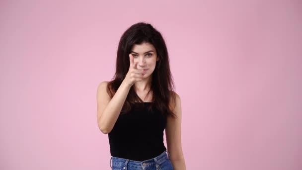 一个女孩的4K慢镜头要求通过粉色背景给某人打电话 情绪的概念 — 图库视频影像